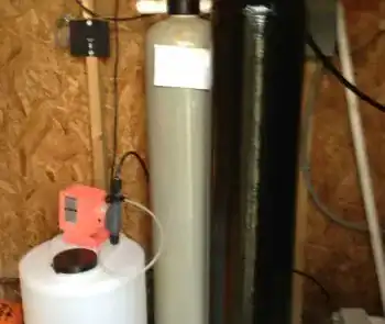 Water treatment system with filters and control panel in a workshop setting.