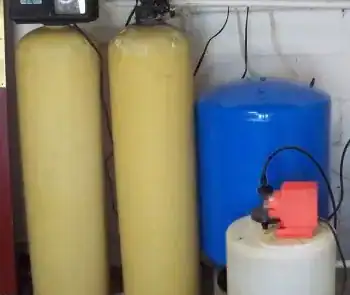 Water treatment system with yellow and blue tanks in a laboratory setting.