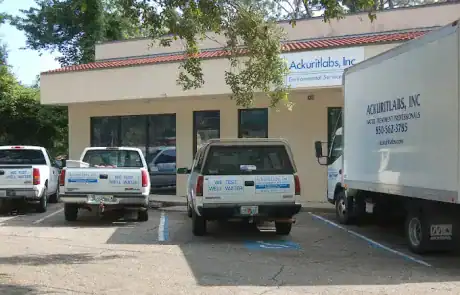 Ackuritlabs Inc. building with water testing vehicles parked outside in a lot.