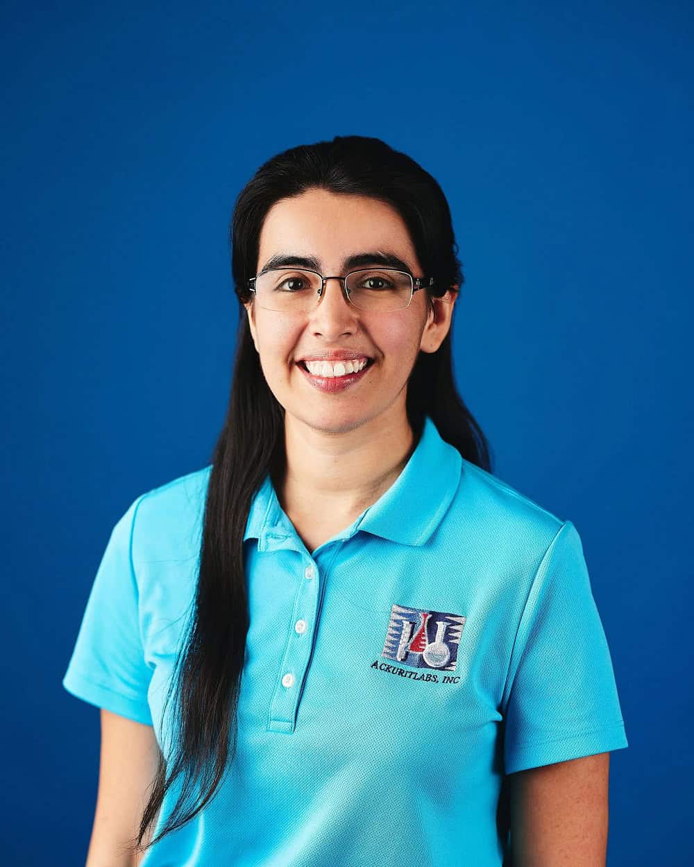 Woman in Aqua Systems uniform smiling against blue background.
