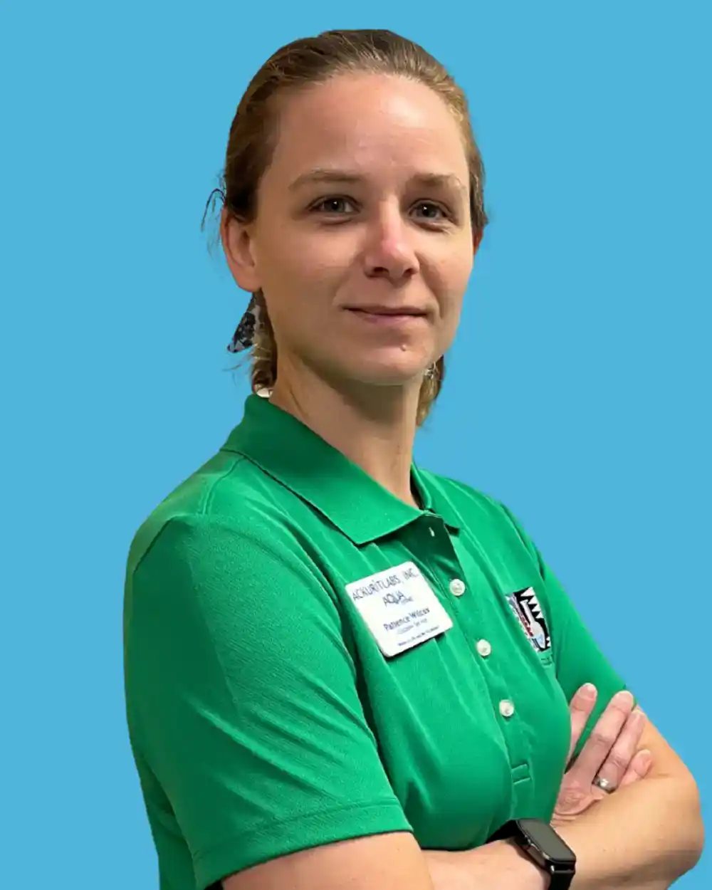 Woman in green polo shirt with Ackuritlabs badge against blue background.