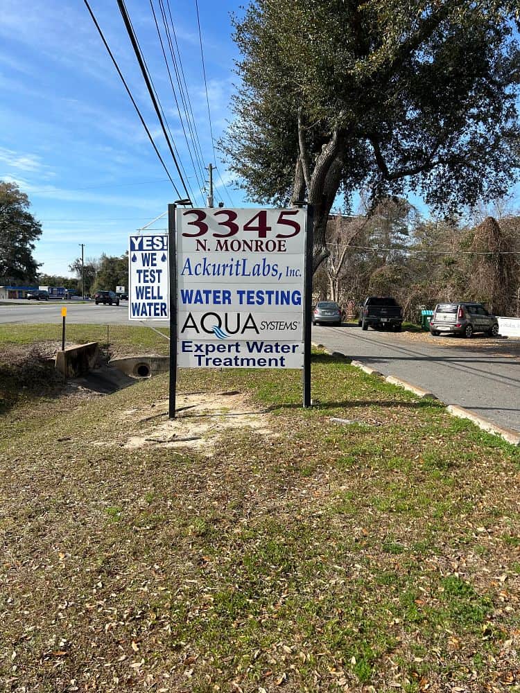 Sign for AckuritLabs and Aqua Systems at 3345 N. Monroe with water testing and treatment services.