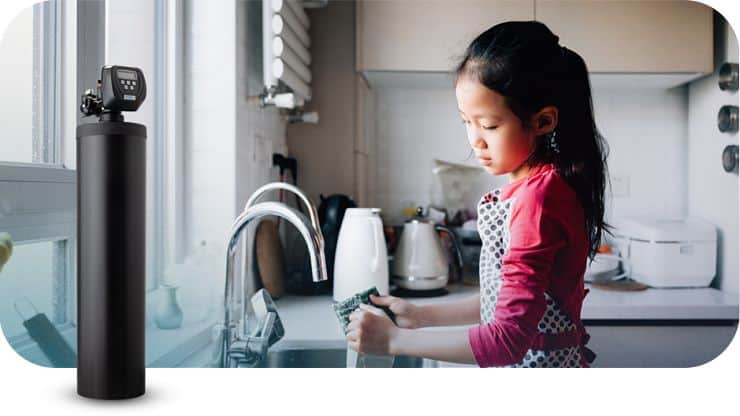 Young girl testing water quality in kitchen with water testing kit.