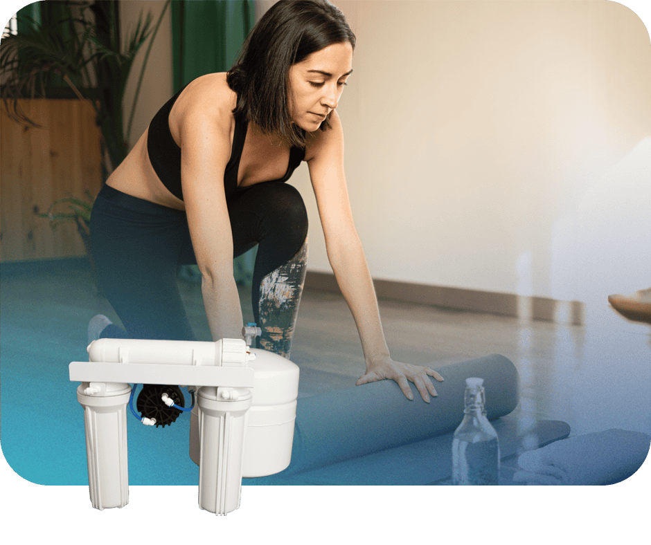 Woman installing water filtration system in a home setting.