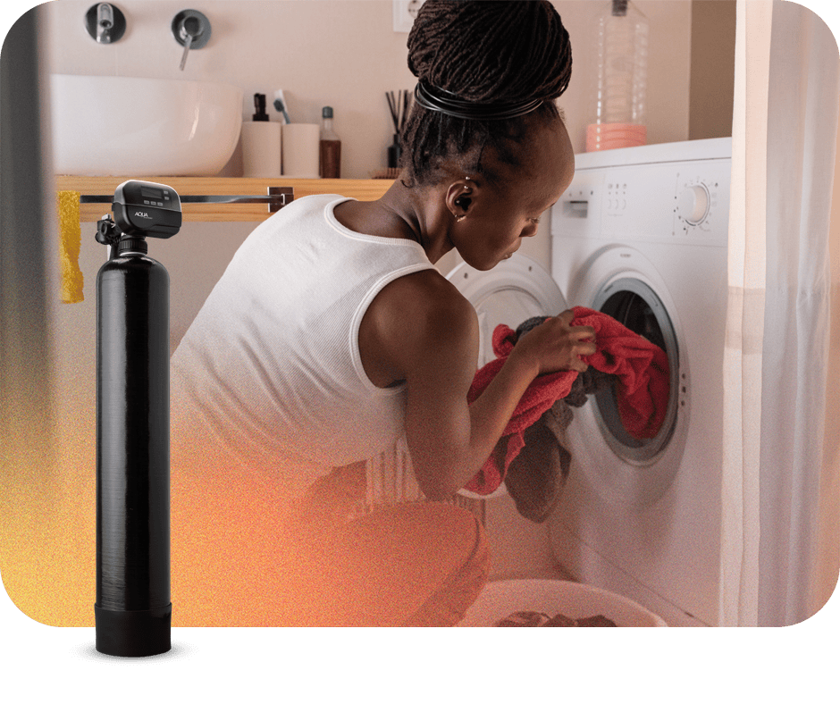 Woman loading laundry into washing machine in a laundry room.