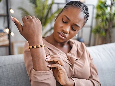 Woman examining her wrist with a bracelet, indoors.