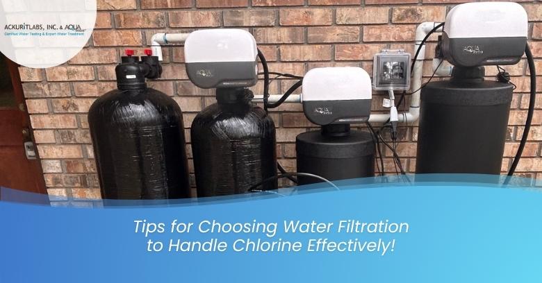 Water filtration system with three black tanks and control units installed on a brick wall.
